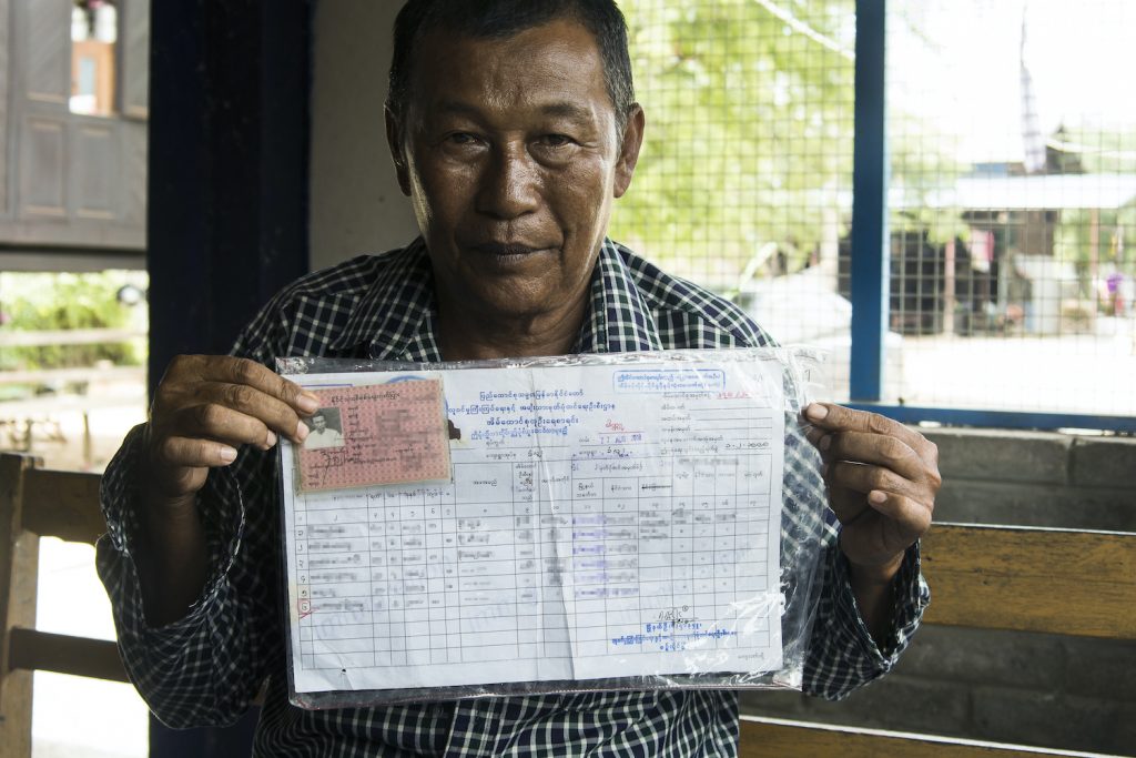 Two Muslim residents of Sintgaing Township's Khanluu village, a man aged 57 and a boy aged 19, present their Citizenship Scrutiny Cards and household member lists. (Teza Hlaing | Frontier)