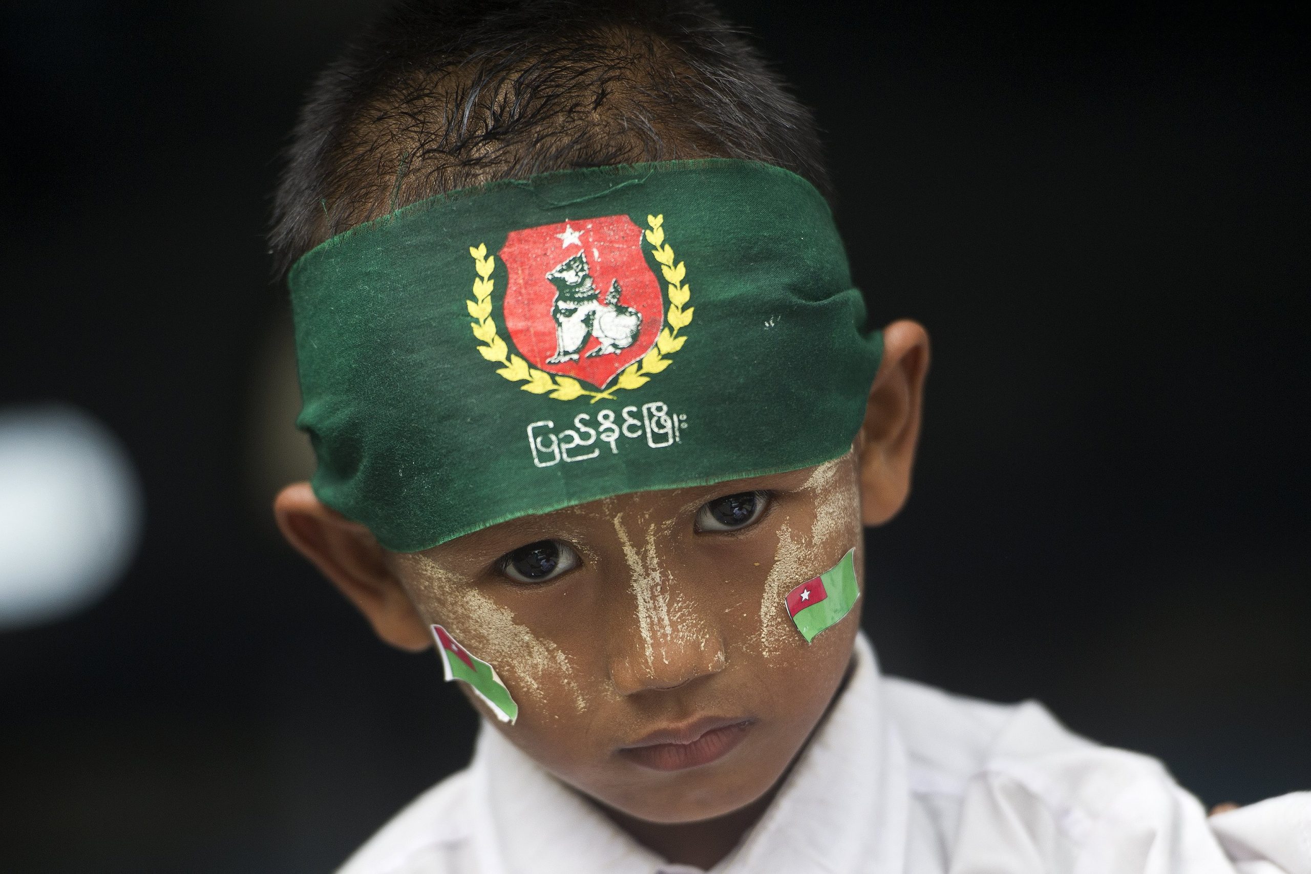 A boy wears a bandana and stickers with the symbols of the military-backed Union Solidarity and Development Party. (AFP)