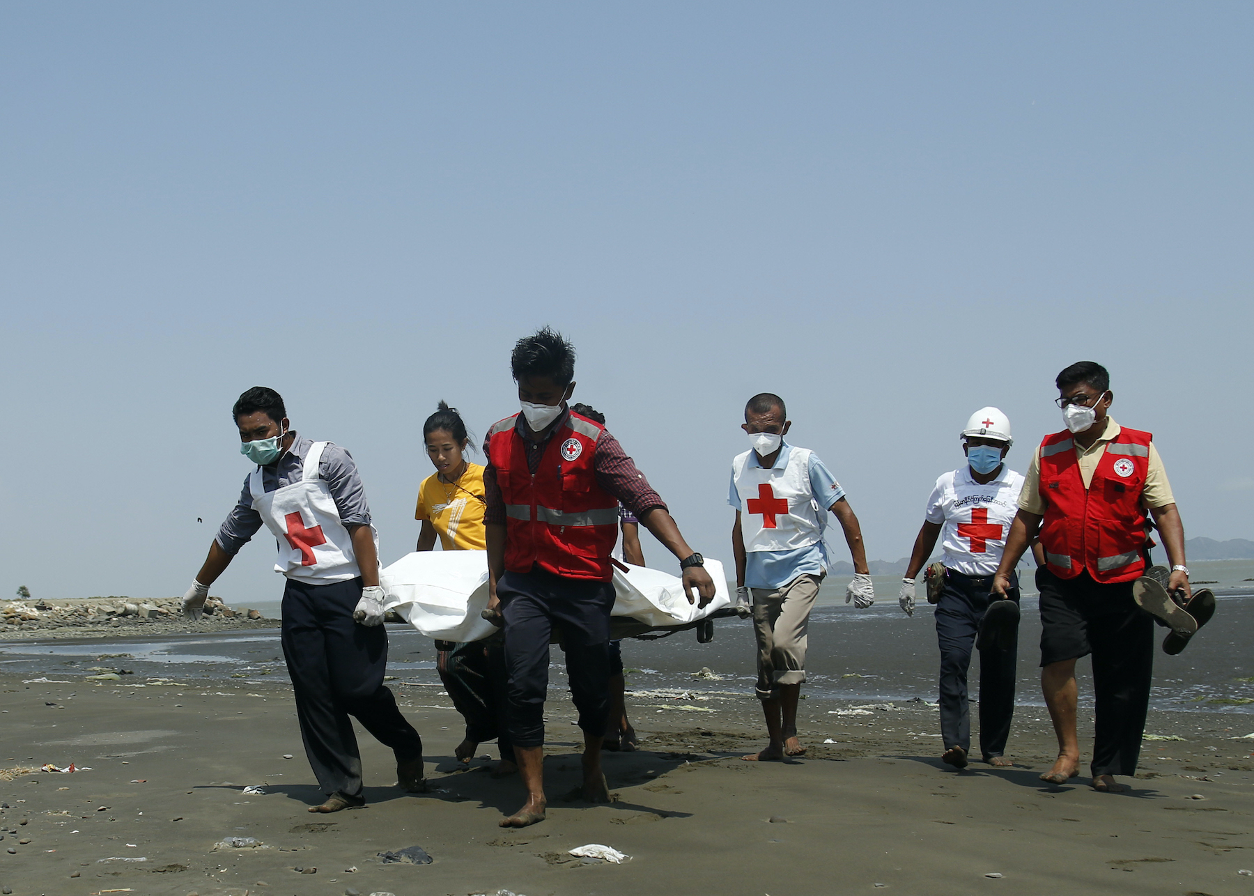 Members of the Myanmar Red Cross carry the body of the driver of a United Nations-marked vehicle after it came under attack while delivering COVID-19 test samples in Sittwe, Rakhine State on April 21. (AFP)