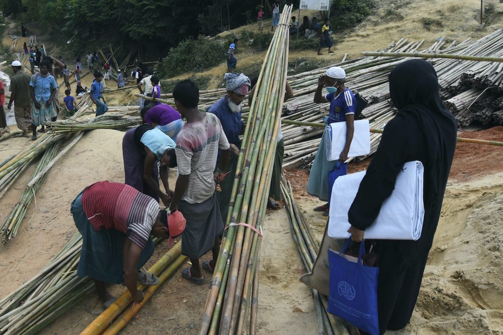 Rohingya refugees collect bamboo poles and other relief supplies at Kutupalong refugee camp in Ukhia on October 15. (AFP)