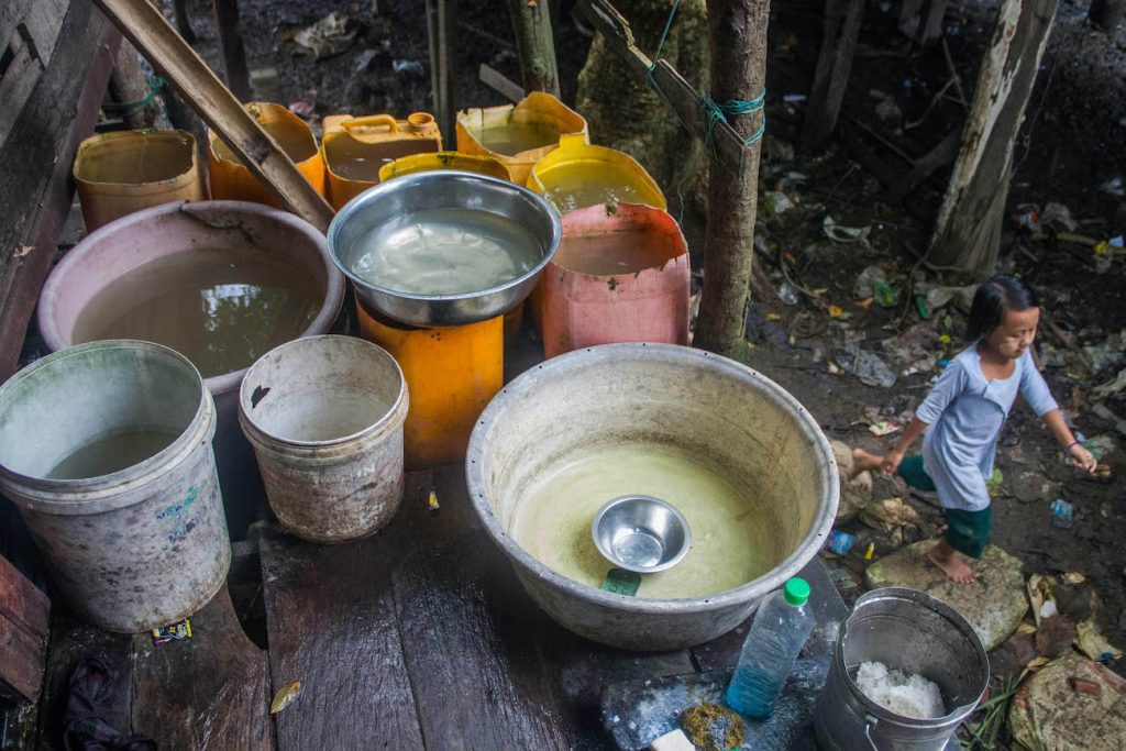 A household in Mawlawmyine's Lamuttan quarter uses bowls and buckets to store water. (Naw Betty Han | Frontier)