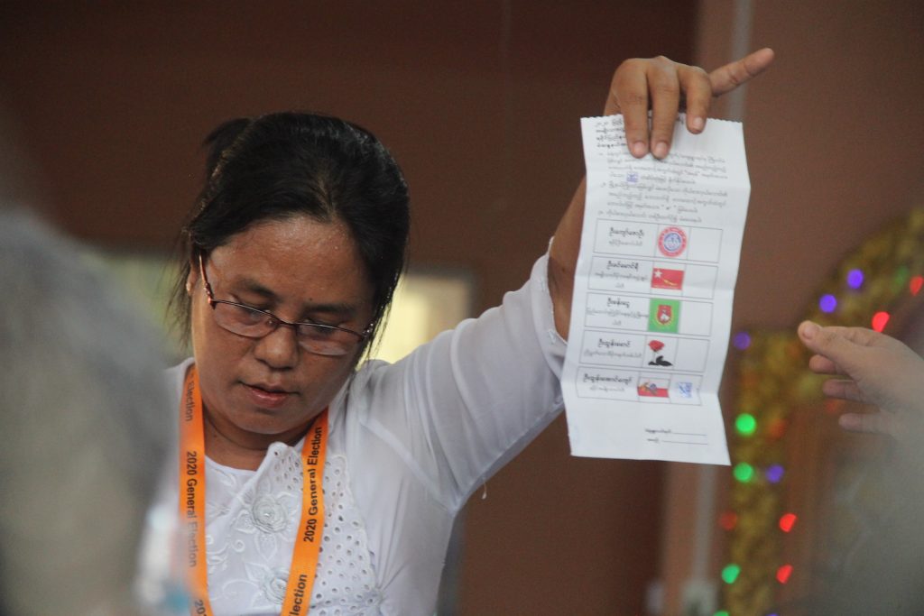 An election sub-commission official in Sittwe holds up a vote for the Arakan National Party. (Kaung Mratt Naing | Frontier)