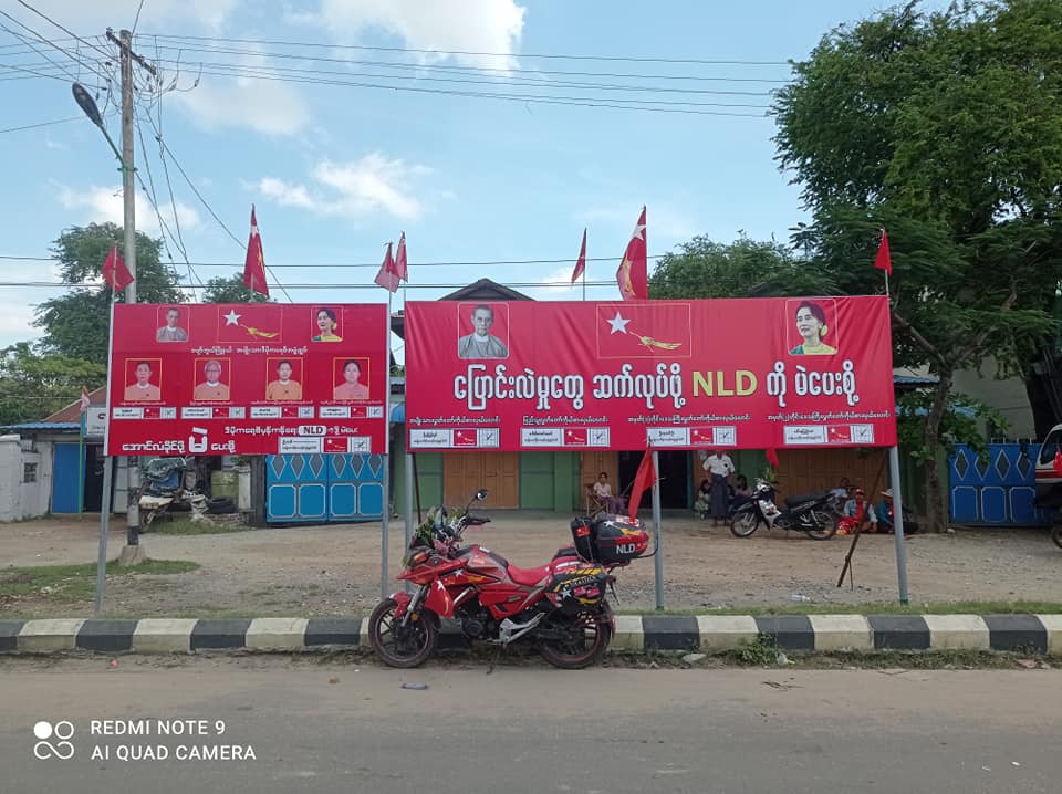 A motorcycle sits beneath signboards promoting the National League for Democracy in the southern Mandalay Region town of Pyawbwe – considered a stronghold of the opposition Union Solidarity and Development Party – in late October. (Supplied)