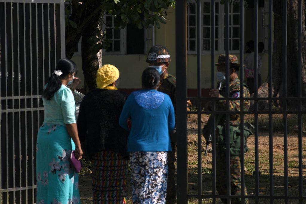 Members of the Arakan Women Network speak to soldiers outside of a military court in Sittwe, Rakhine State, on December 11, after a rare legal victory for a woman who was brutally raped by Tatmadaw soldiers. (AFP)