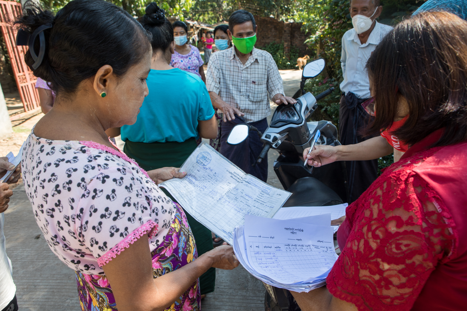 NLD staff survey residents of Yangon Region's Hmawbi Township on November 26, after complaints arose over which households did or did not receive payouts under the government's COVID-19 cash relief programme. (Thuya Zaw | Frontier)