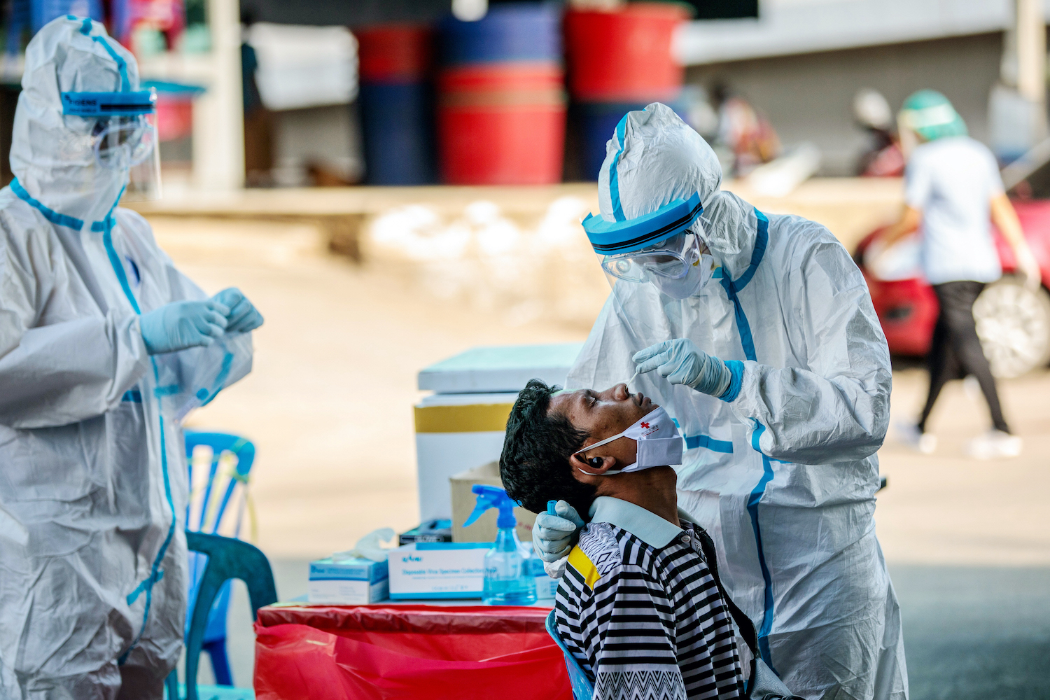 Medical officials test a man for the COVID-19 at a seafood market in the migrant hub of Samut Sakhon on December 19, two days after the virus was detected in a worker from Myanmar. (AFP)