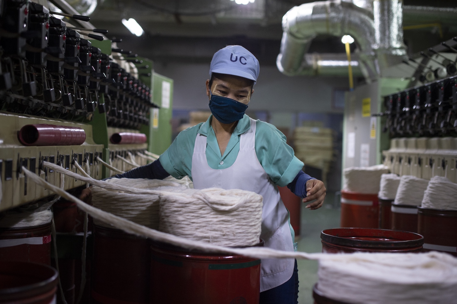 A Myanmar migrant worker handles barrels of cotton in a textile factory in Pathum Thani Province, Thailand. (AFP)