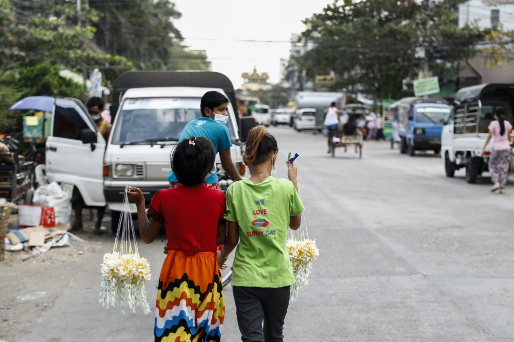 Two young girls sell flowers to support their families in Yangon on December 21. (Nyein Su Wai Kyaw Soe | Frontier)