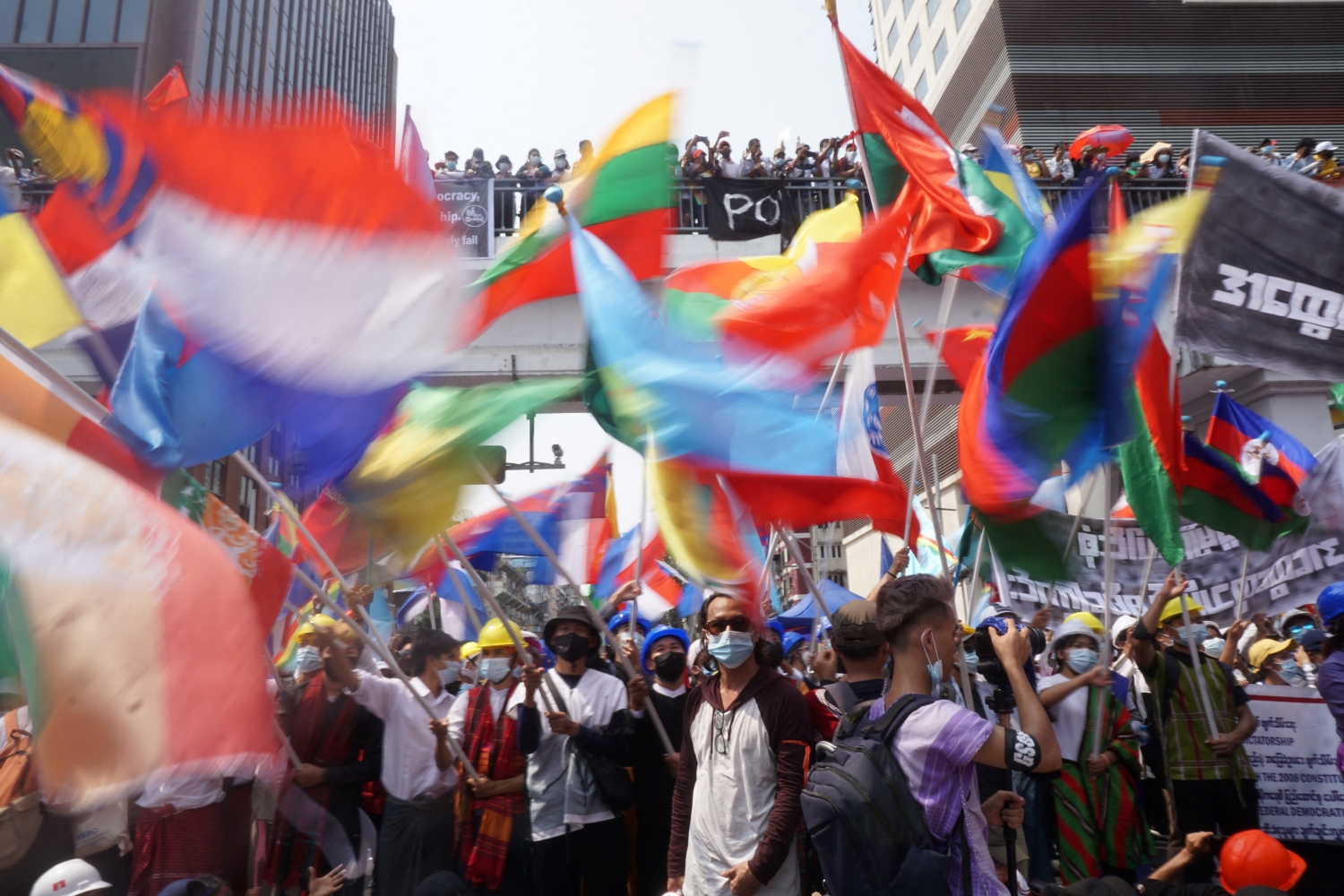 Protesters wave the flags of different ethnic nationalities while marching through Yangon on February 18 to oppose military rule. (AFP)