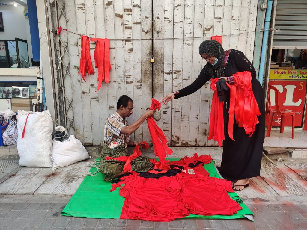 Some Yangon street vendors have shifted their wares from hats and purses to red ribbons and NLD flags to supply the growing protest movement.