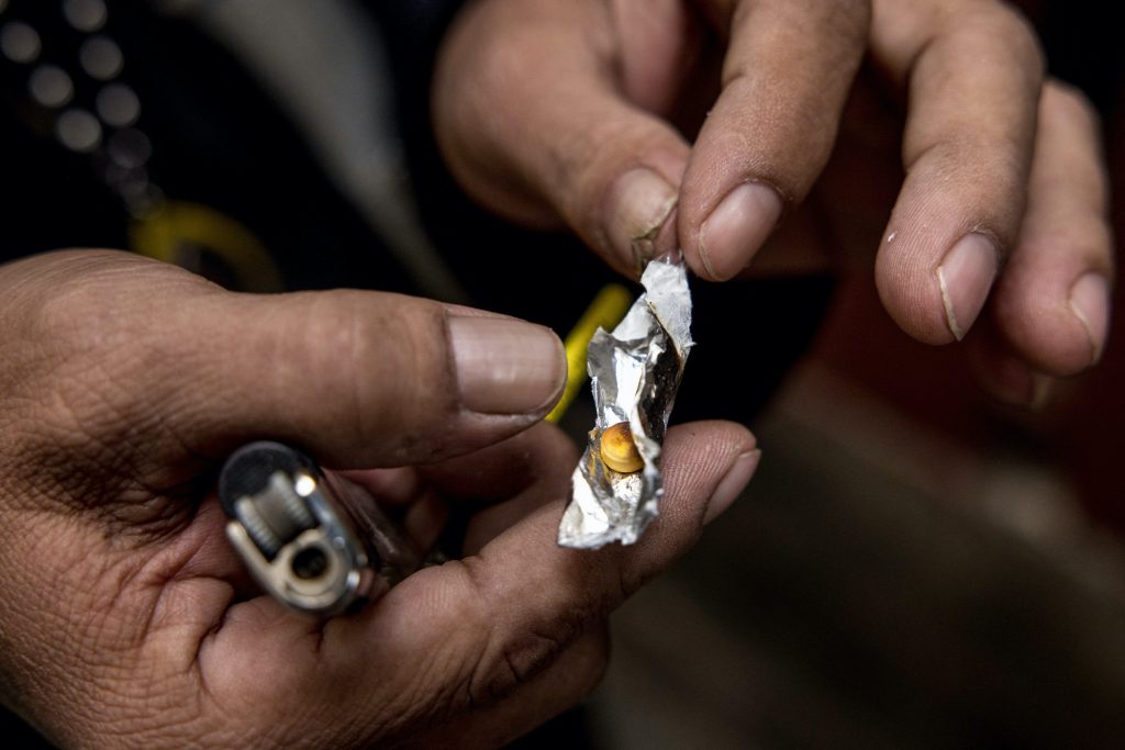 A motorbike taxi driver holds a yaba methamphetamine pill while demonstrating how he consumes the drug during an interview with AFP in Bangkok. (AFP)