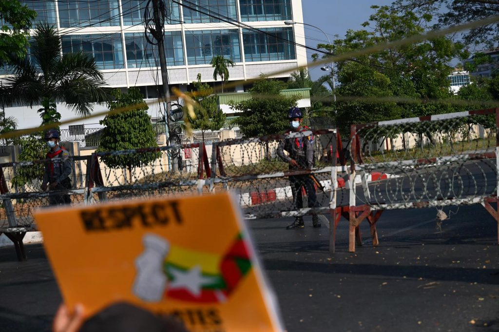 Police look on behind a barricade as protesters hold a demonstration outside the Central Bank of Myanmar branch in Yangon on February 16. (Frontier)