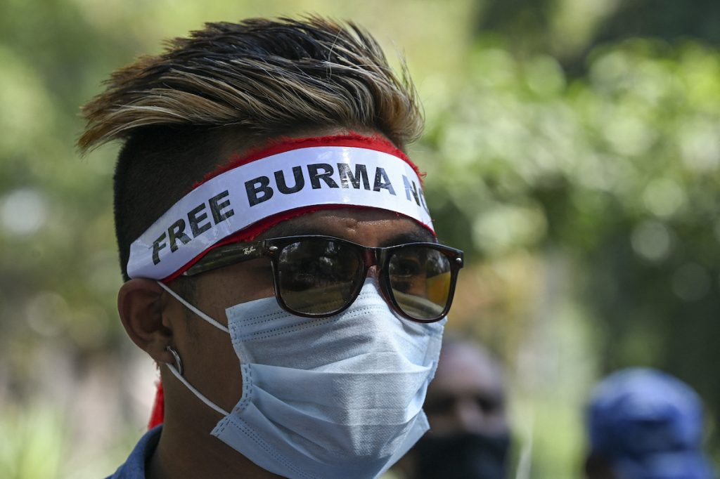 Myanmar refugees hold placards during a demonstration in New Delhi on March 3 to protest against the military coup. (AFP)