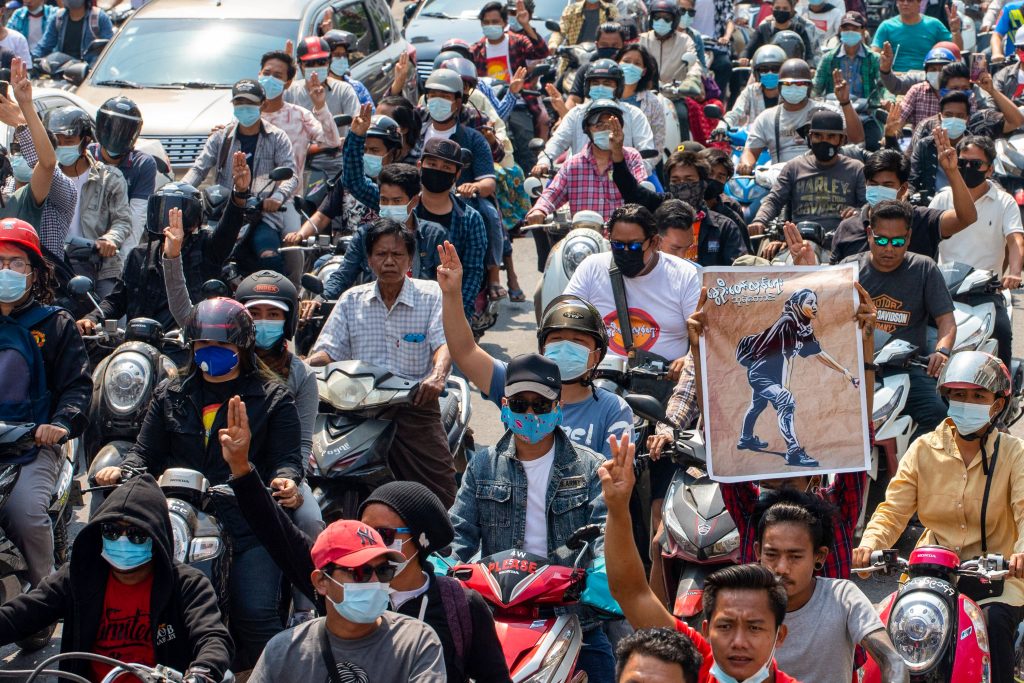 A man holds up a poster featuring protester Ma Kyal Sin during her funeral procession in Mandalay today. (AFP)