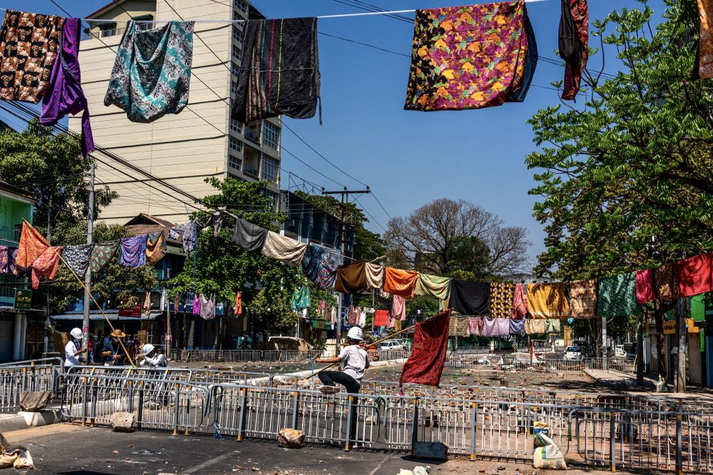 Rows of htamein hang above lines of barricades in the Kyaukmyaung area of Tarmwe Township on March 8. The women's garments are hung to deter superstitious members of the security forces. (Frontier)