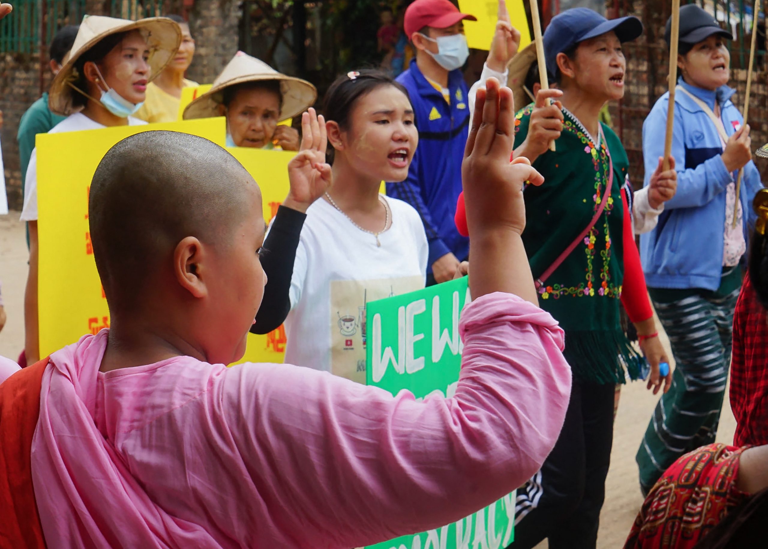 A young Buddhist novice nun holds up the three-finger salute to anti-coup protesters in Karen National Union-administered Dooplaya District, Kayin State, on April 2. (KNU / AFP)