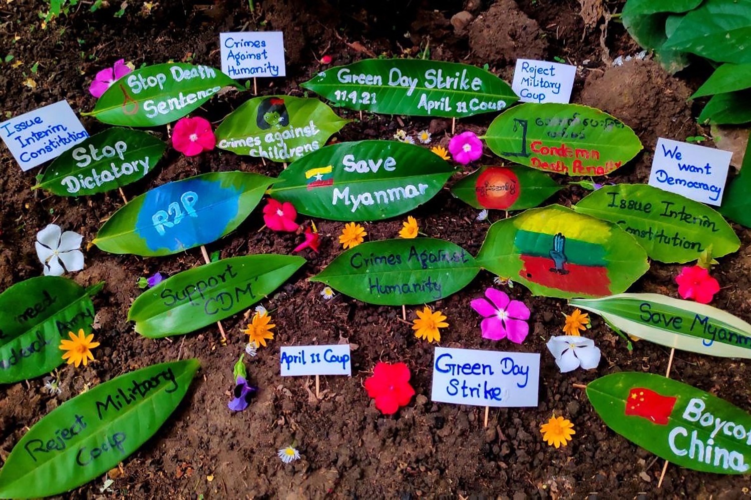 Plant leaves display dissident slogans as part of a "Green Day Strike" staged by protesters in Mon State’s Ye Township on April 11. (Facebook / AFP)