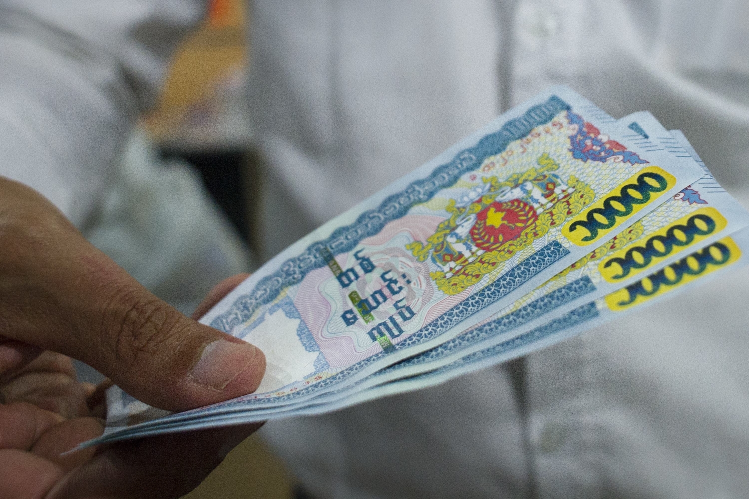 A man holds 10,000 kyat notes. (AFP)