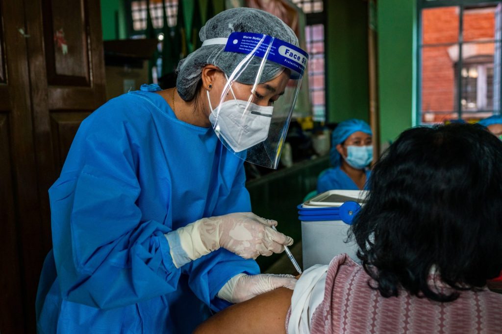 A health worker administers a first dose of the Indian-made Covishield COVID-19 vaccine at the Basic Education High School No. 4 in Botahtaung Township, Yangon, on February 5. (Frontier)