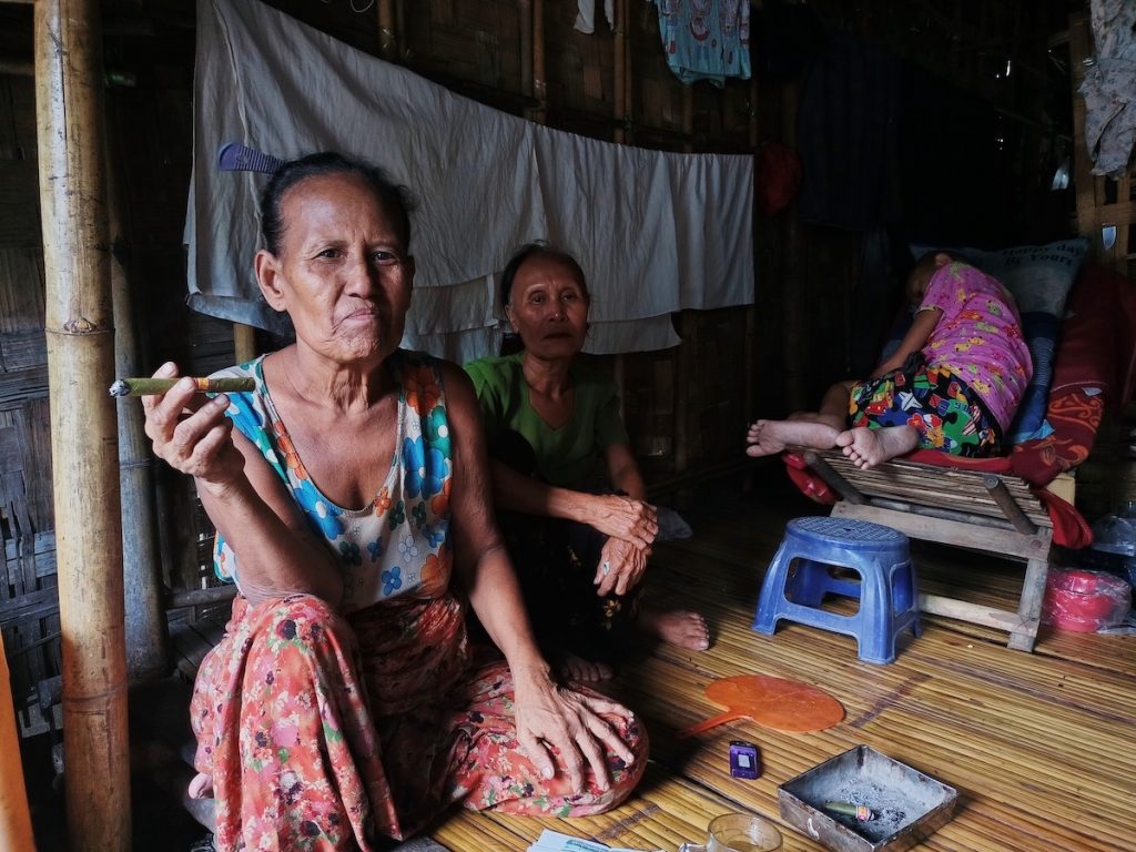 Daw Tin Tin, 66, smokes a cheroot in the informal housing she shares with relatives in the Yay Oak Kan section of Yangon's Hlaing Tharyar Township on May 1. (Frontier)