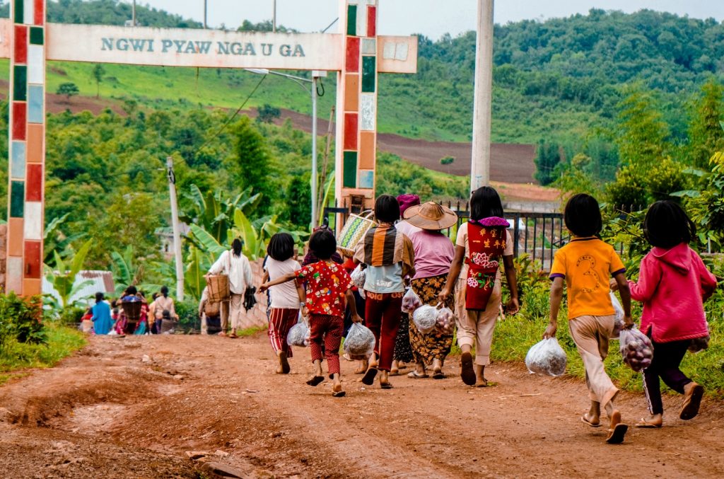 Villagers on June 10 carry food aid distributed by volunteers in Pankai village, in northern Shan State's Kutkai Township, where local authorities say villagers are struggling to obtain daily necessities due to continued conflict between the Tatmadaw and Northern Alliance. (MNWN / AFP)