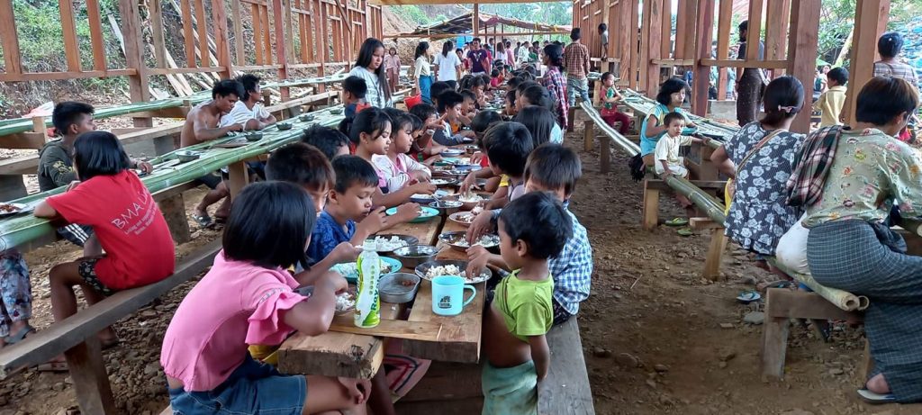 Children at an open-air dining site in the camp for displaced people at Lukse on May 22. (Supplied)