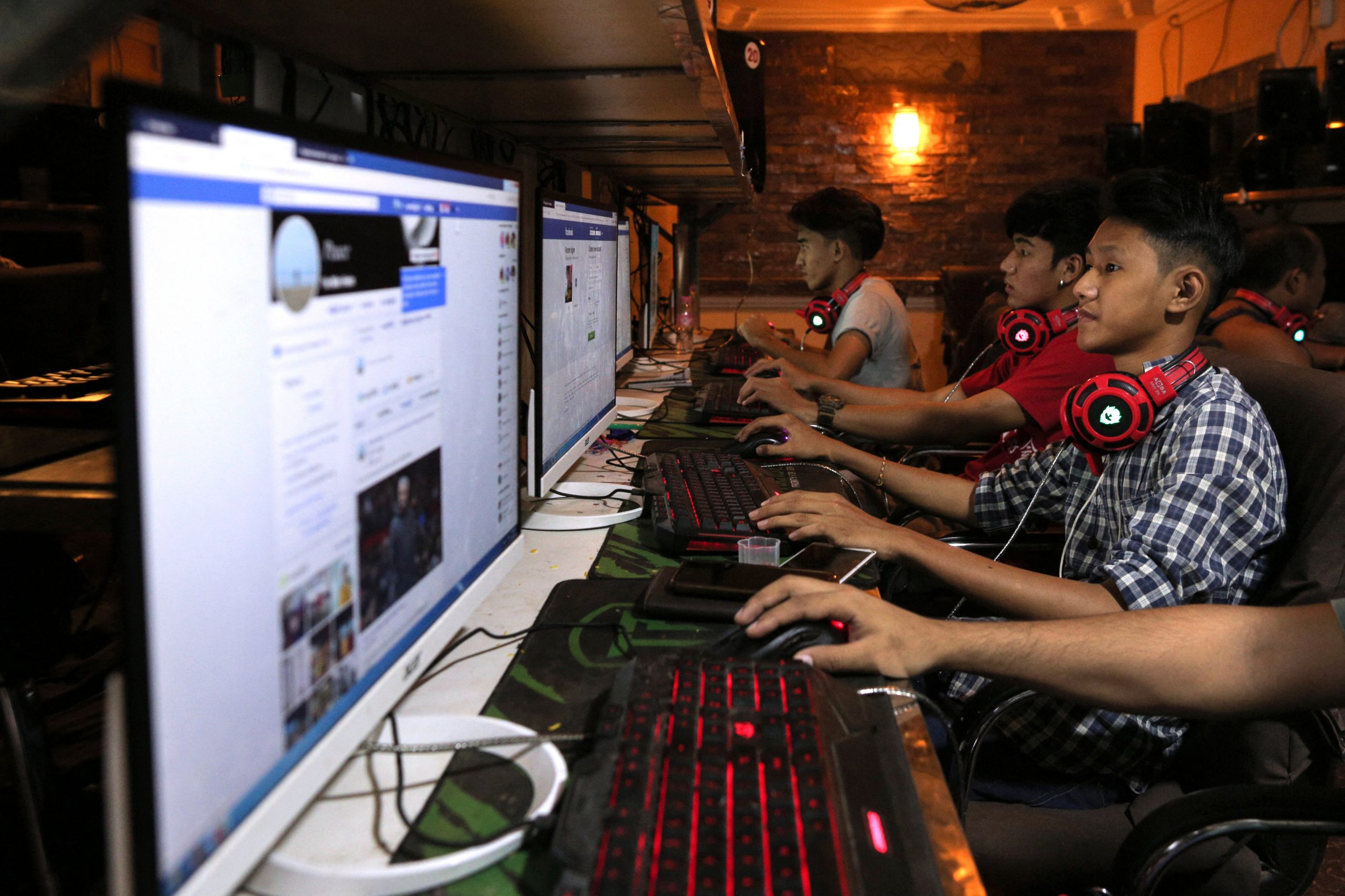 Youths browse Facebook at a Yangon cybercafe on December 18, 2018. (AFP)