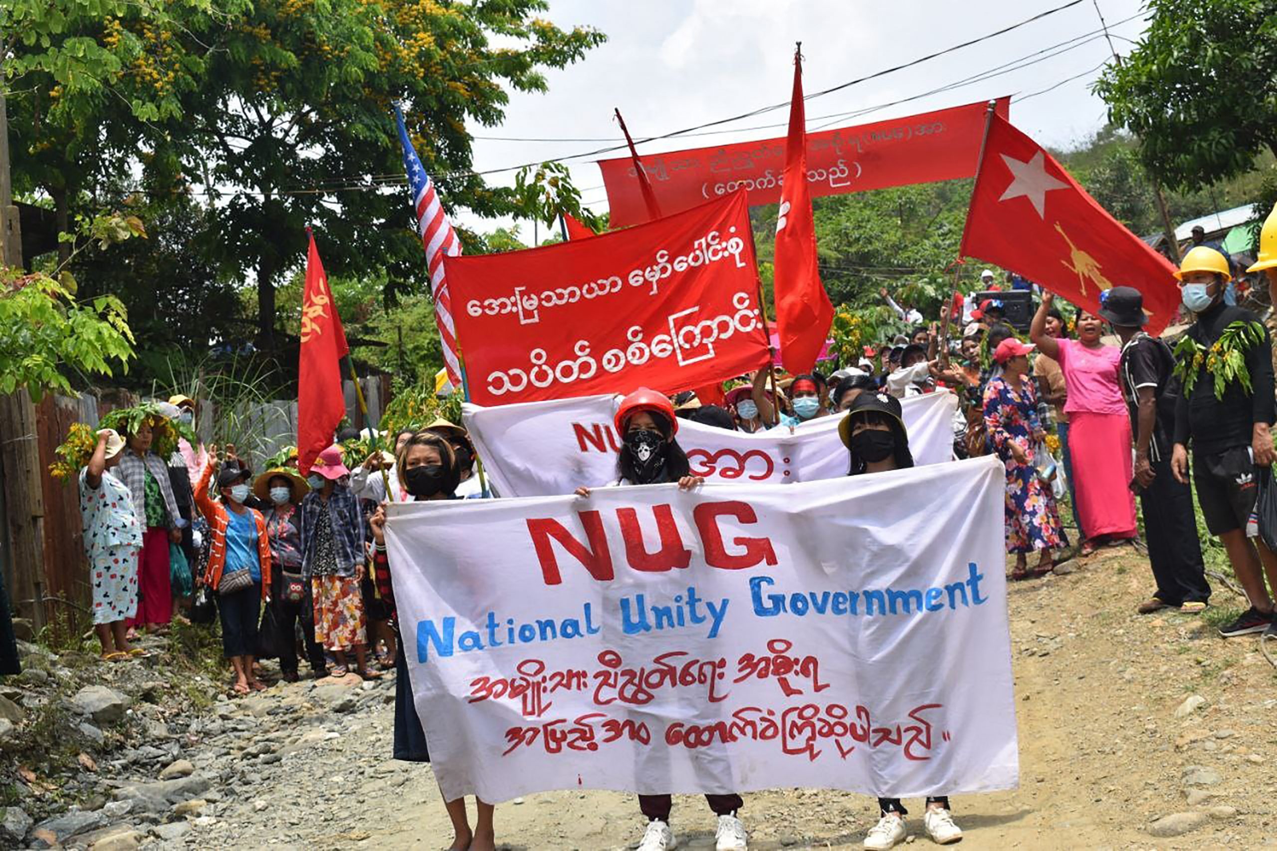 Protesters marching with banners in support of the National Unity Government in Hpakant in May 2021. (KACHINWAVES/AFP)