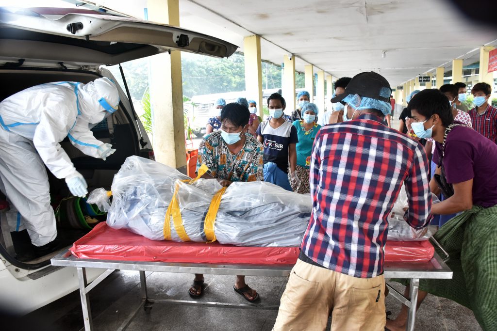 Volunteers and staff unload a body at the crematorium in Yay Way cemetery in Yangon's North Okkalapa Township on July 28. (Frontier)