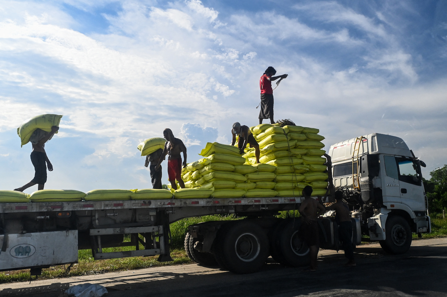 Labourers load rice bags onto a truck in Thanlyin township in Yangon in October 2021. (AFP)