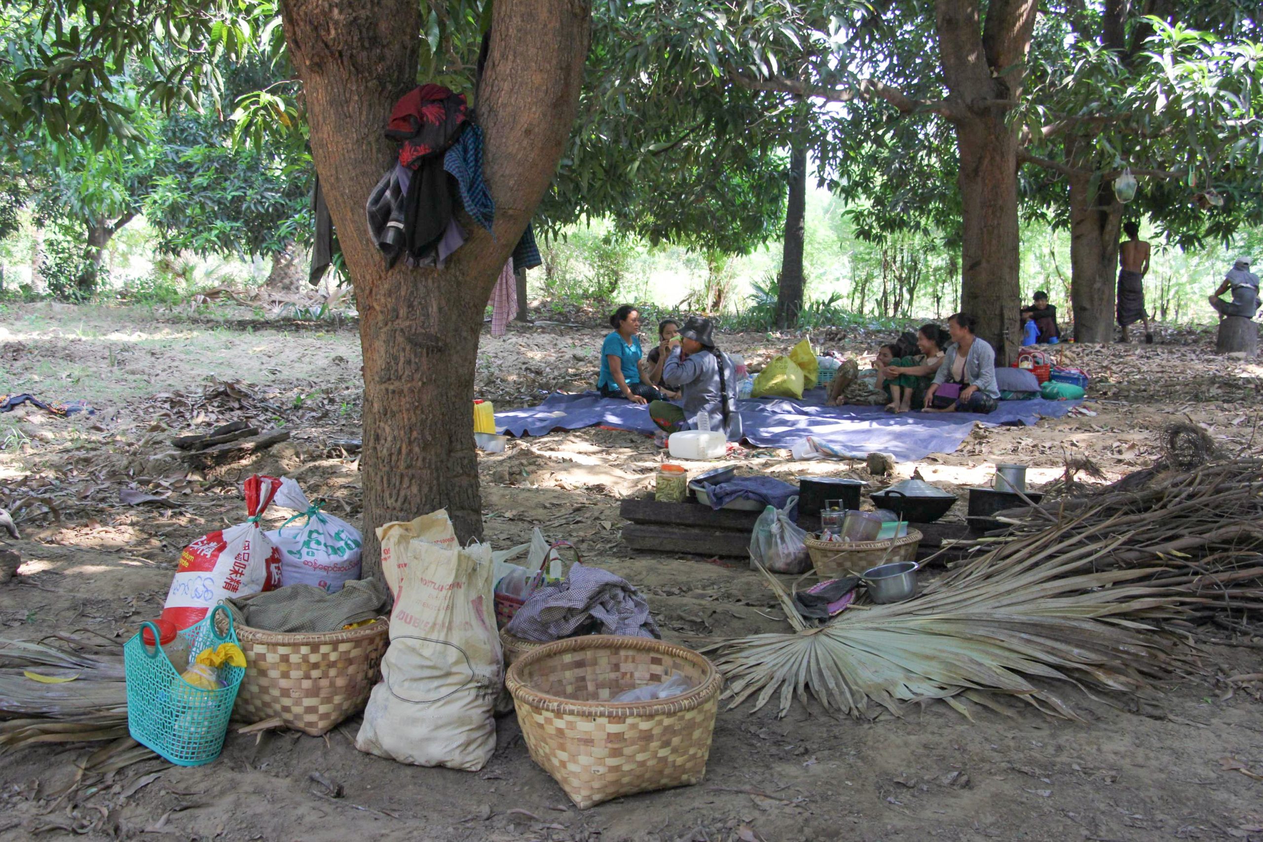 Residents of Thi Tin village in Sagaing Region resting with supplies in a nearby forest after the village was burned down in April. (Supplied)