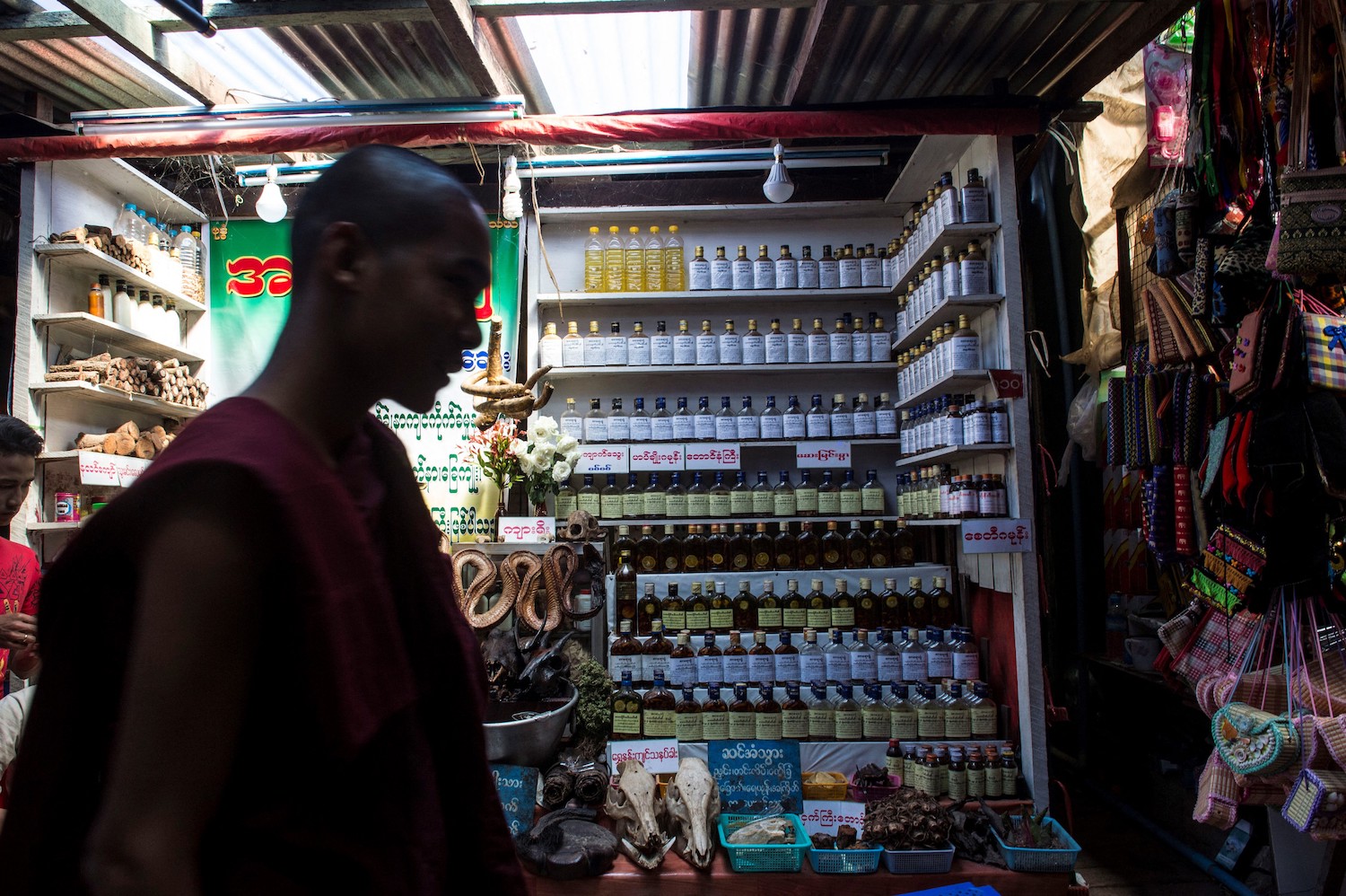 A Buddhist monk walks past a traditional medicine shop in Mon State in 2017. (AFP)