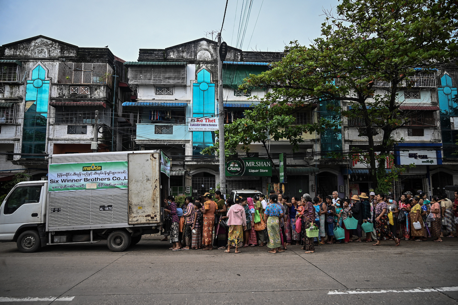 People queue to buy subsidised vegetable oil in Yangon in August 2022. The economy has collapsed under the military regime, one possible contributing factor to the rise of suicide cases. (AFP)