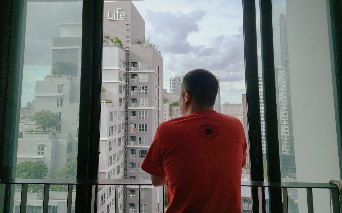 Ye Mon looks out from a balcony in Thailand in September. (Frontier)