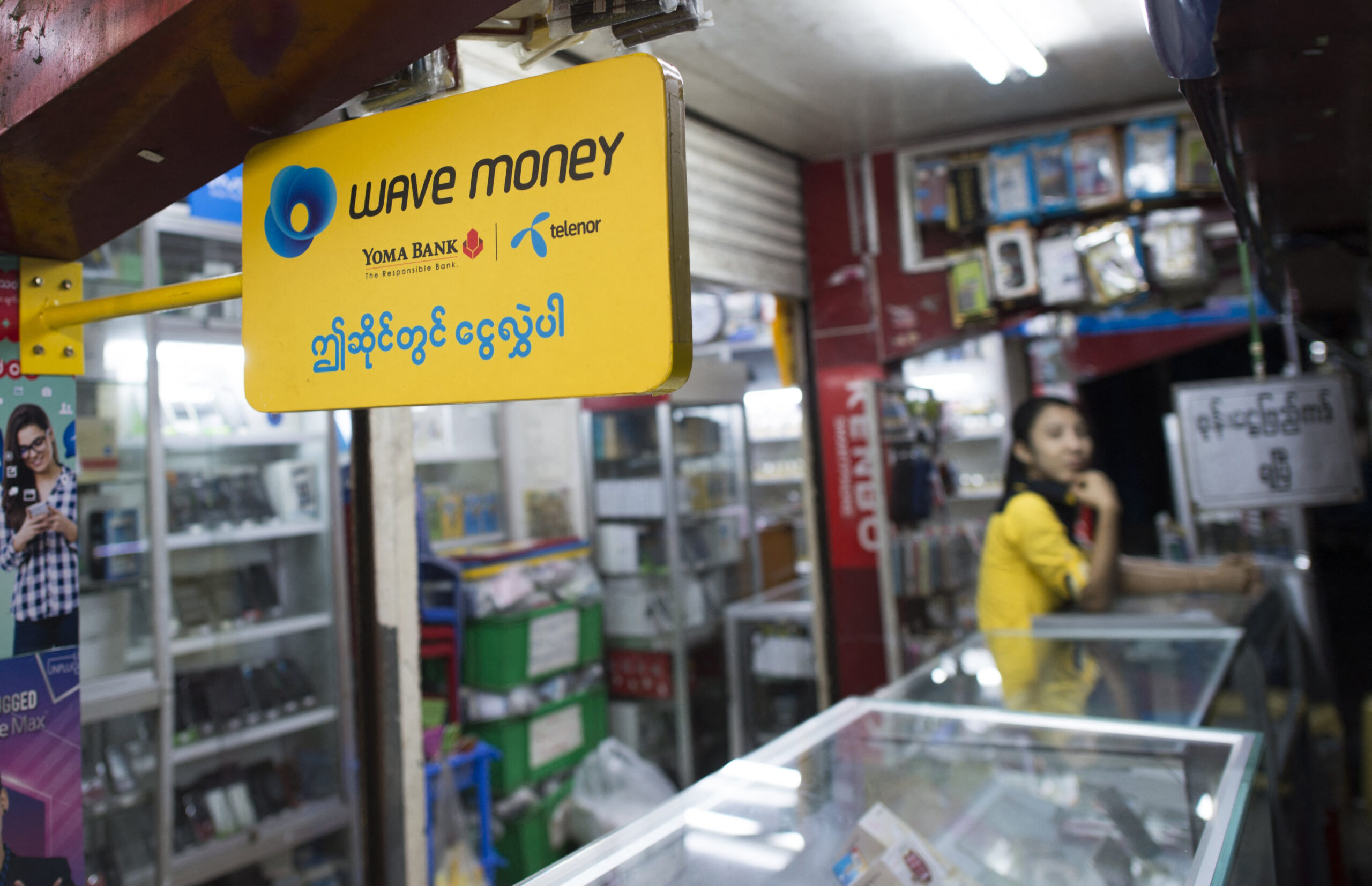 A shop owner advertises the Wave Money mobile banking service. (AFP)