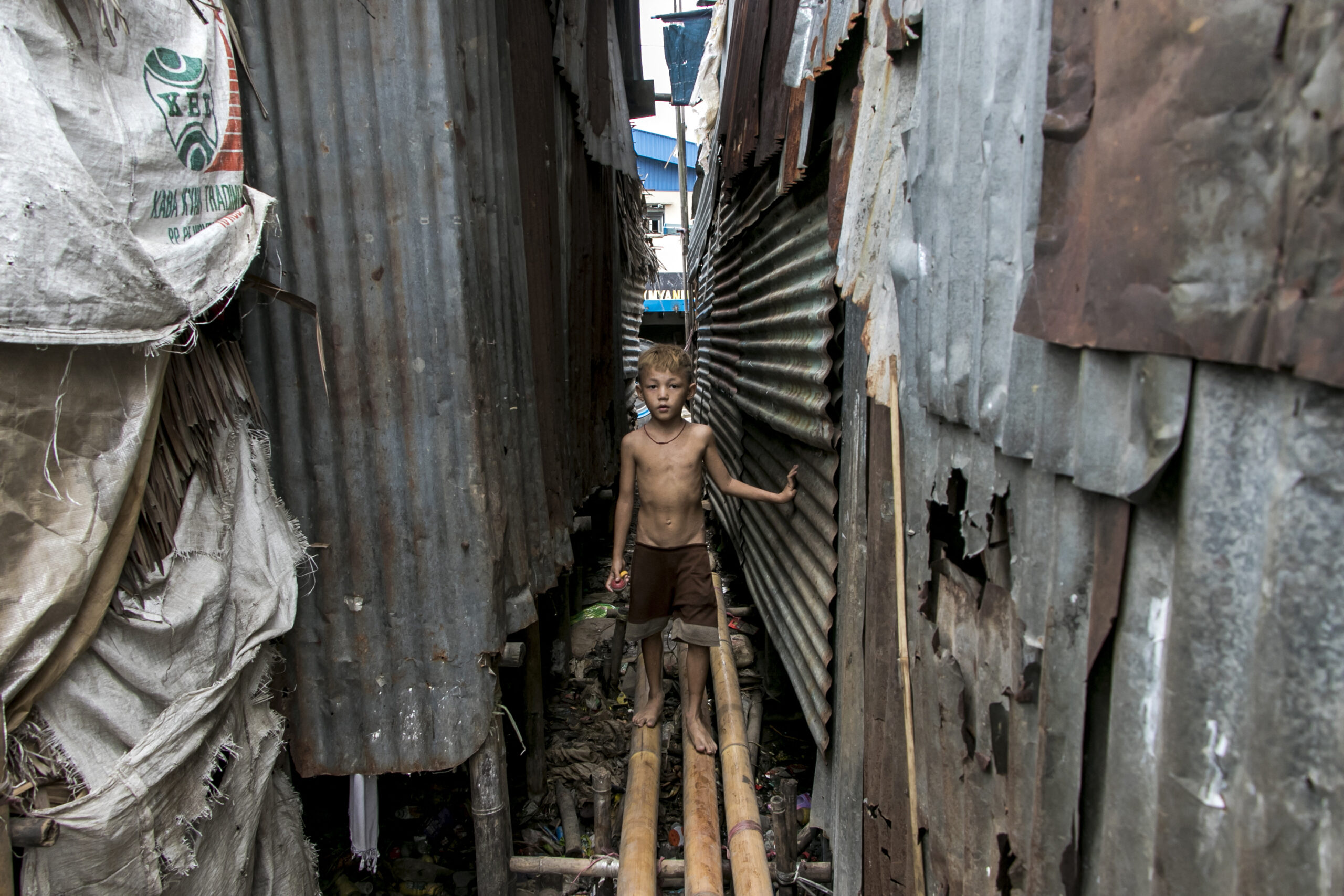 A young boy walks on a bamboo bridge by his home in a poor community on the outskirts of Yangon. (AFP)