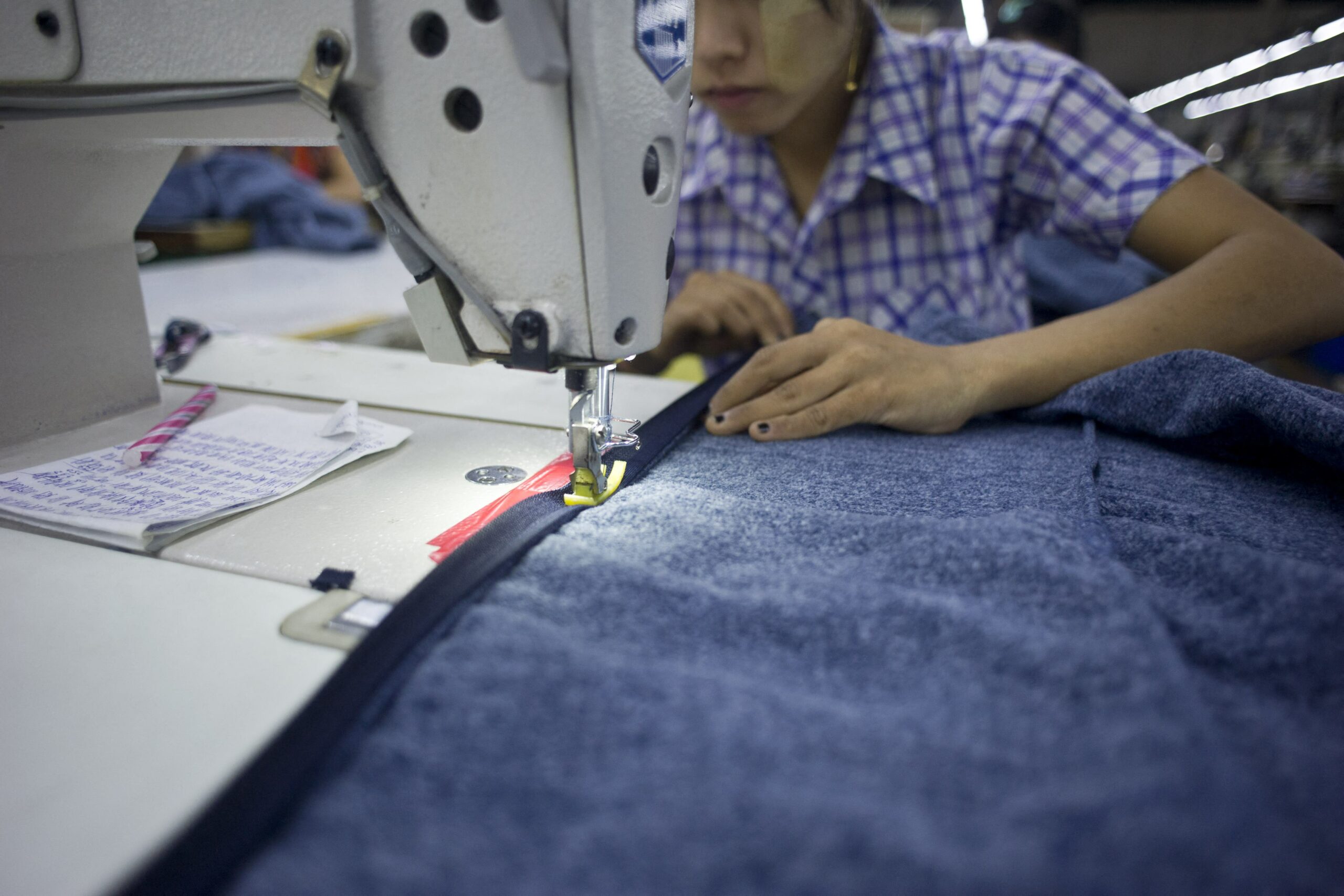 An employee sews clothes at a garment factory at the Shwepyithar industrial zone in Yangon. (AFP)