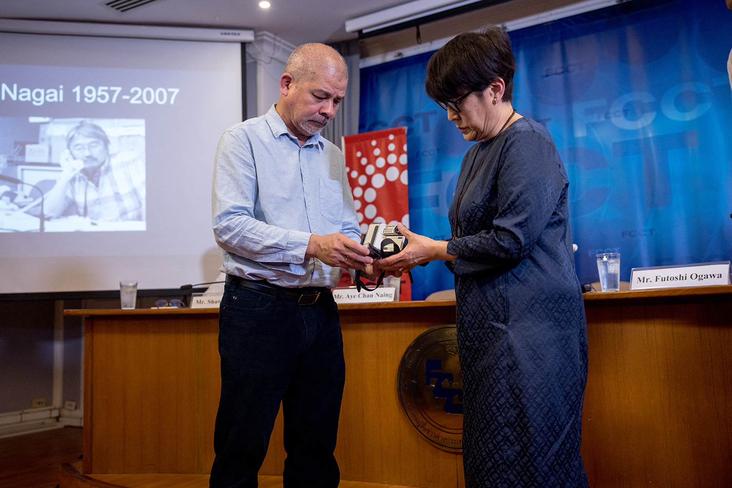 Noriko Ogawa, sister of the late Japanese journalist Kenji Nagai, who was shot dead in Yangon while covering the Saffron Revolution in 2007, receives his camera from journalist Aye Chan Naing in Bangkok on April 26, 2023. (AFP)