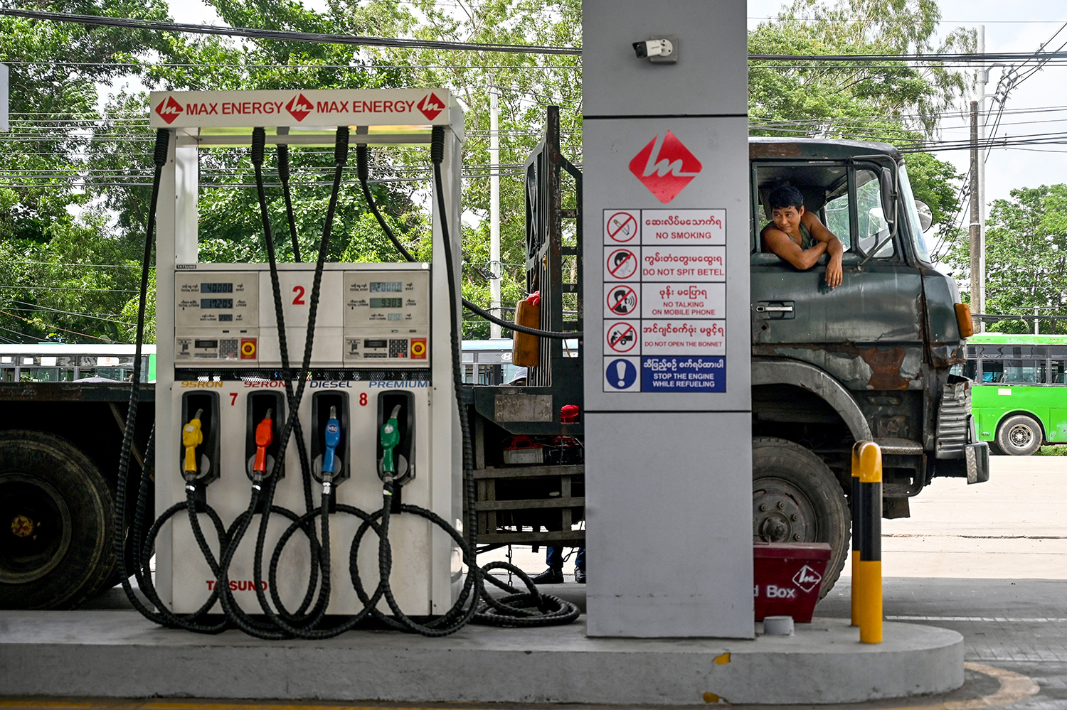 A driver waits for his vehicle to be refuelled at a petrol station in Yangon on May 21, 2022. (AFP)