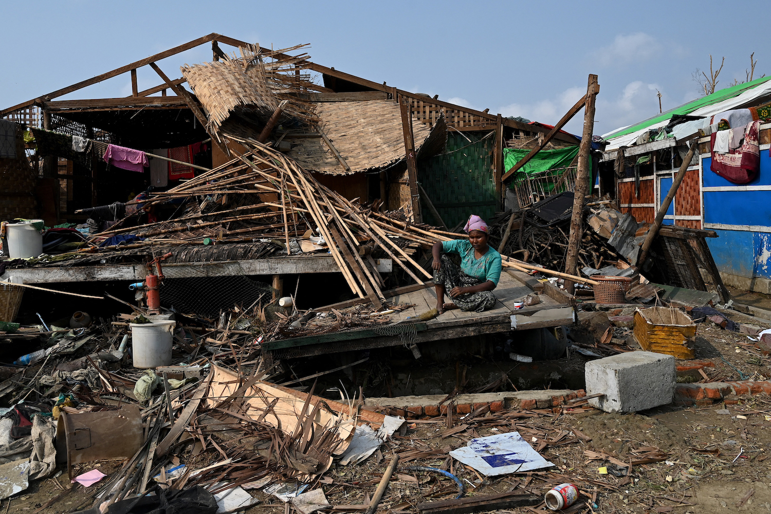 A Rohingya woman sits by her destroyed home in Sittwe. While Rakhine State was hit the hardest, Cyclone Mocha also caused devastation in Sagaing, Magway and Chin. (AFP)