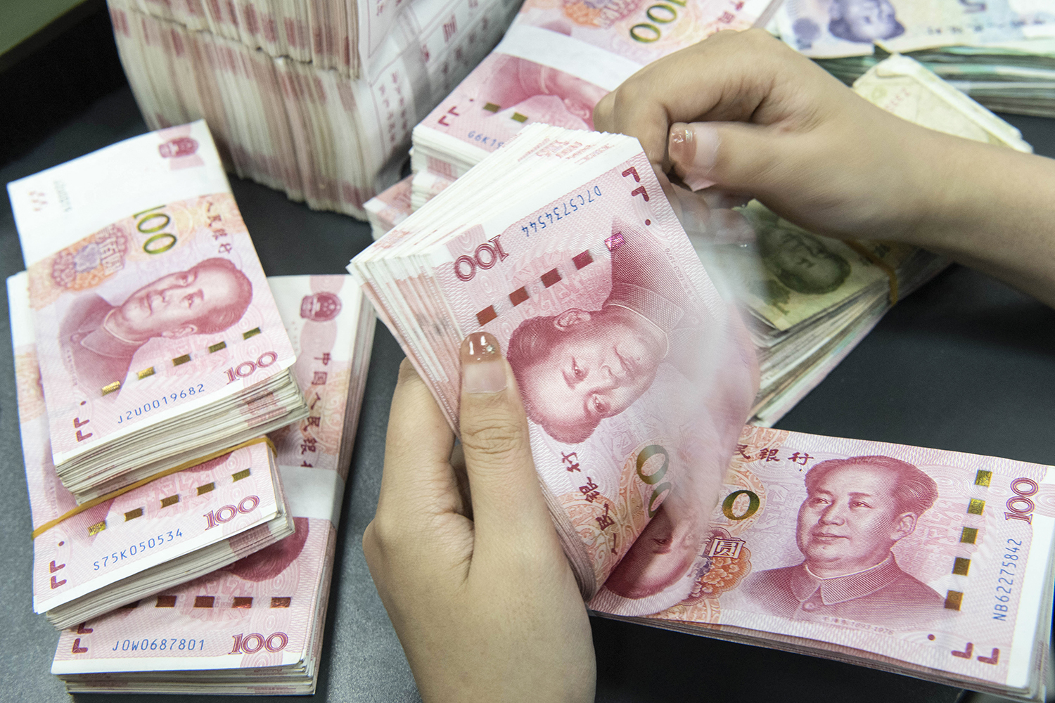 A bank employee counts 100-yuan notes in Nantong, in China's eastern Jiangsu province, on June 13. (AFP)