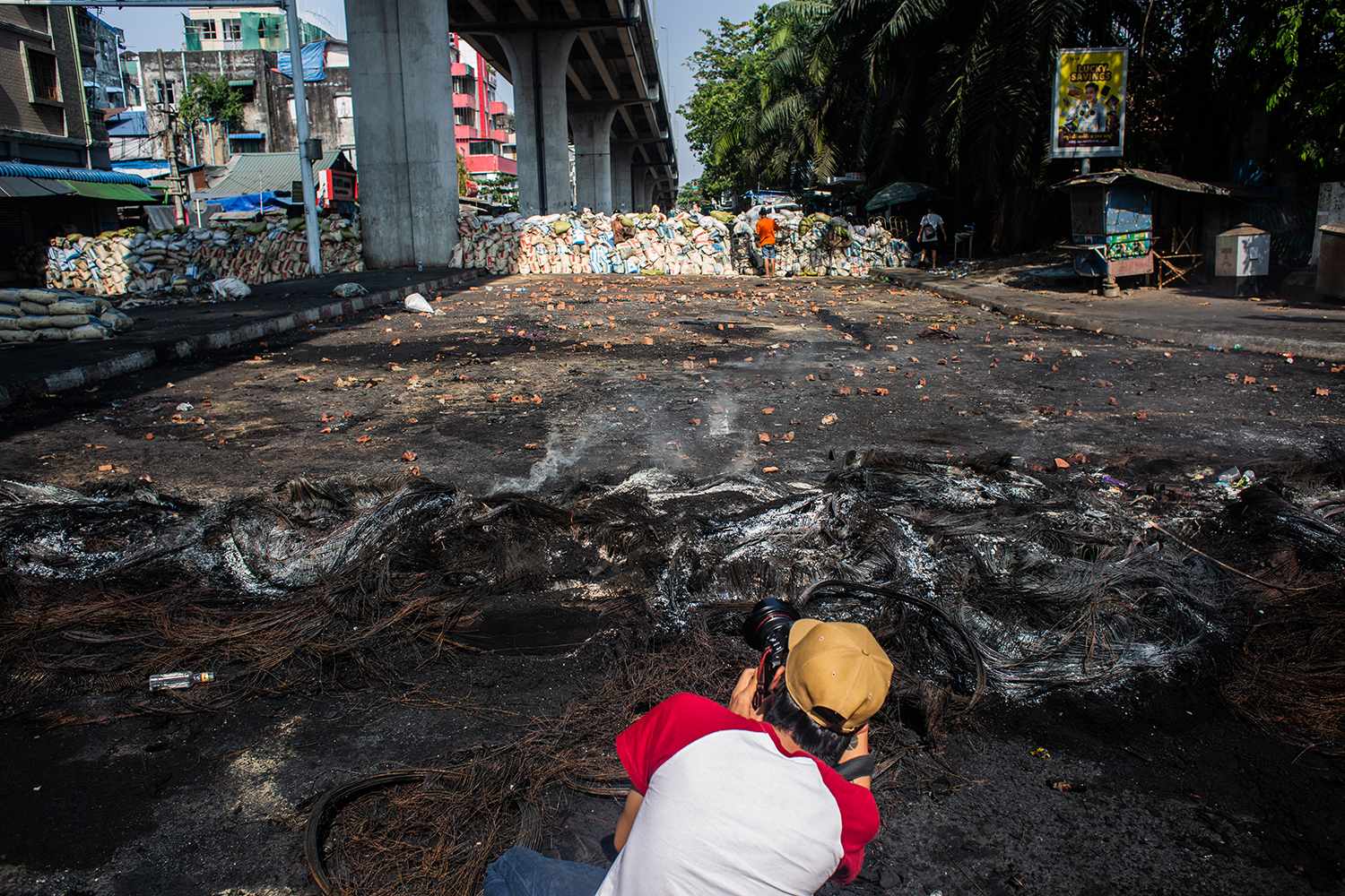 A Myanmar photojournalist takes pictures of a barricade erected by anti-coup protestors in Yangon on March 16, 2021. (Mar Naw | Frontier)