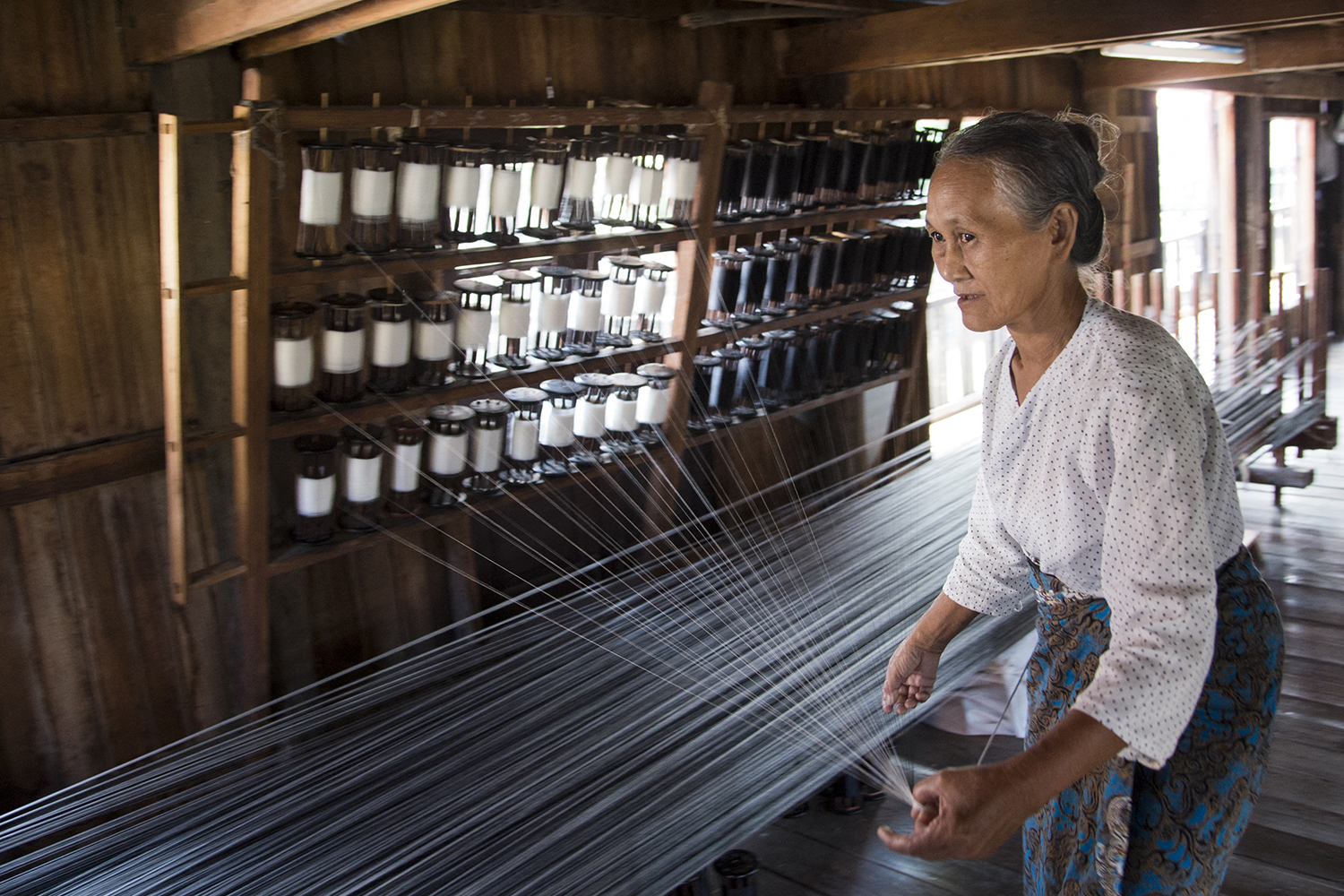 A woman weaves in a workshop in southern Shan State’s Kyainton village on December 3, 2013. (AFP)