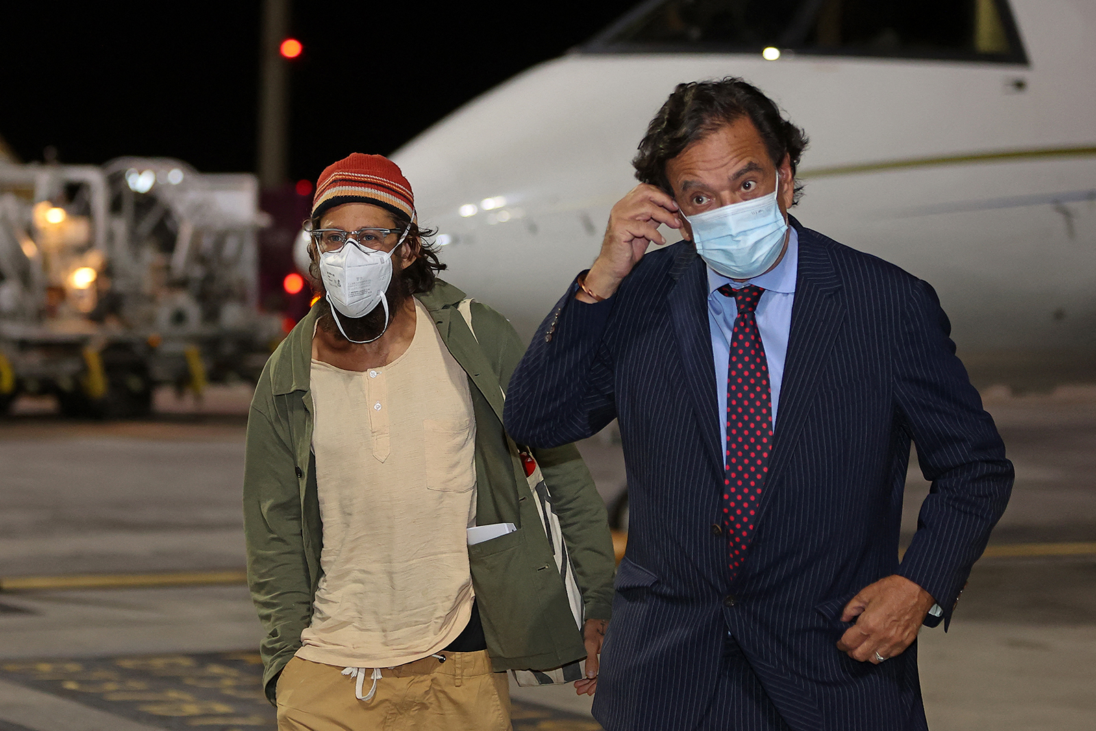 Frontier editor Danny Fenster disembarks from an aircraft alongside former US diplomat Bill Richardson upon their arrival at Hamad International Airport in Doha on November 15, 2021, after Fenster's release from jail in Myanmar. (AFP)