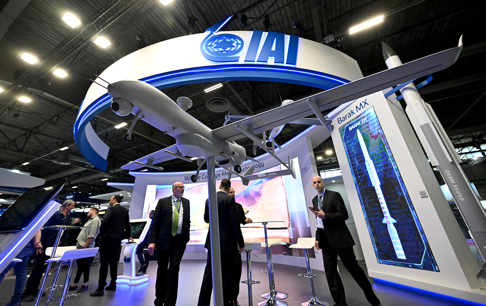 Visitors stand on the booth of the defence technology company Israel Aerospace Industries at an arms fair in Villepinte, France, on June 13, 2022. (AFP)