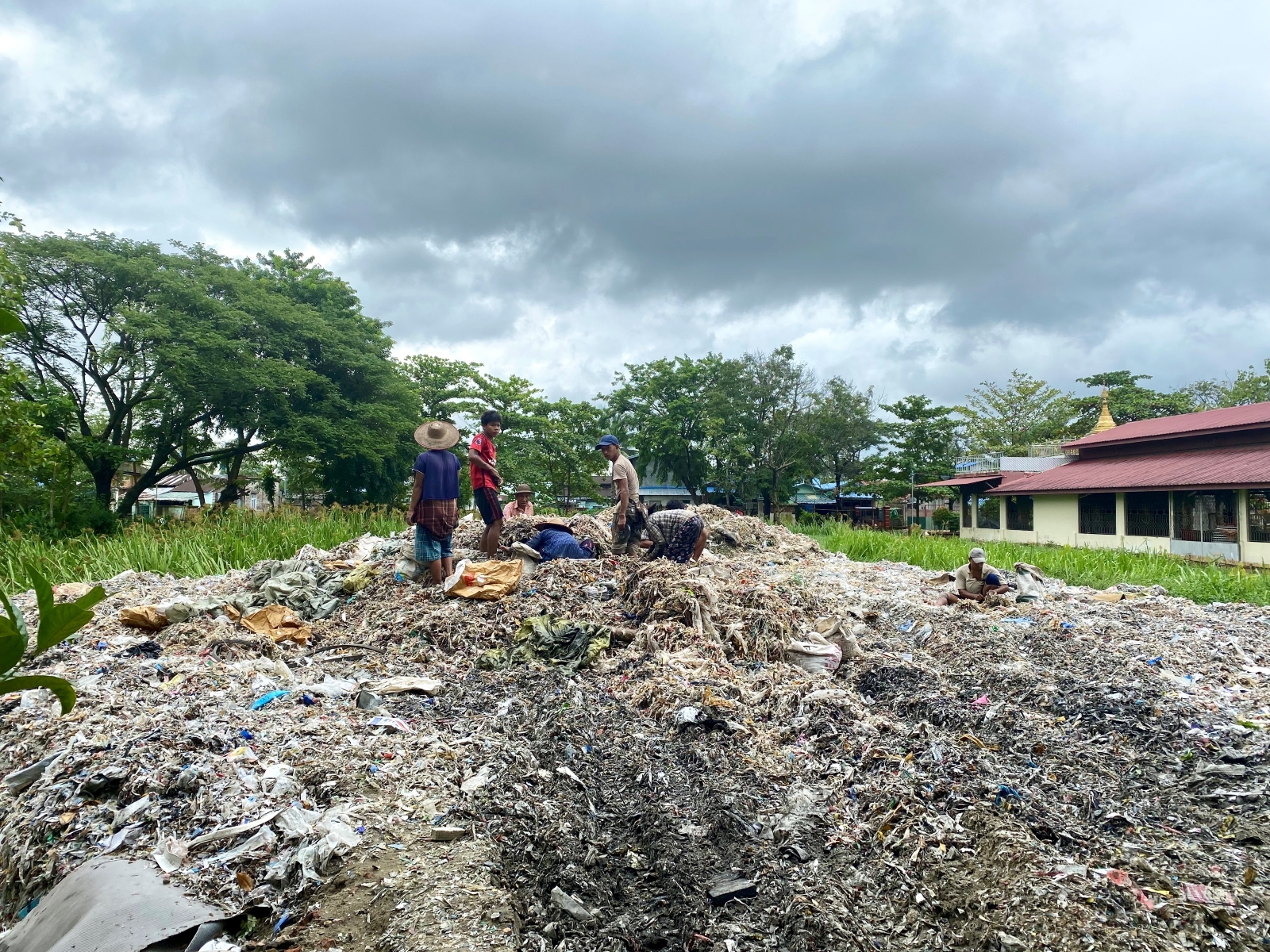 Waste collectors sift through trash in Yangon's Shwepyithar Township in July. (Frontier)