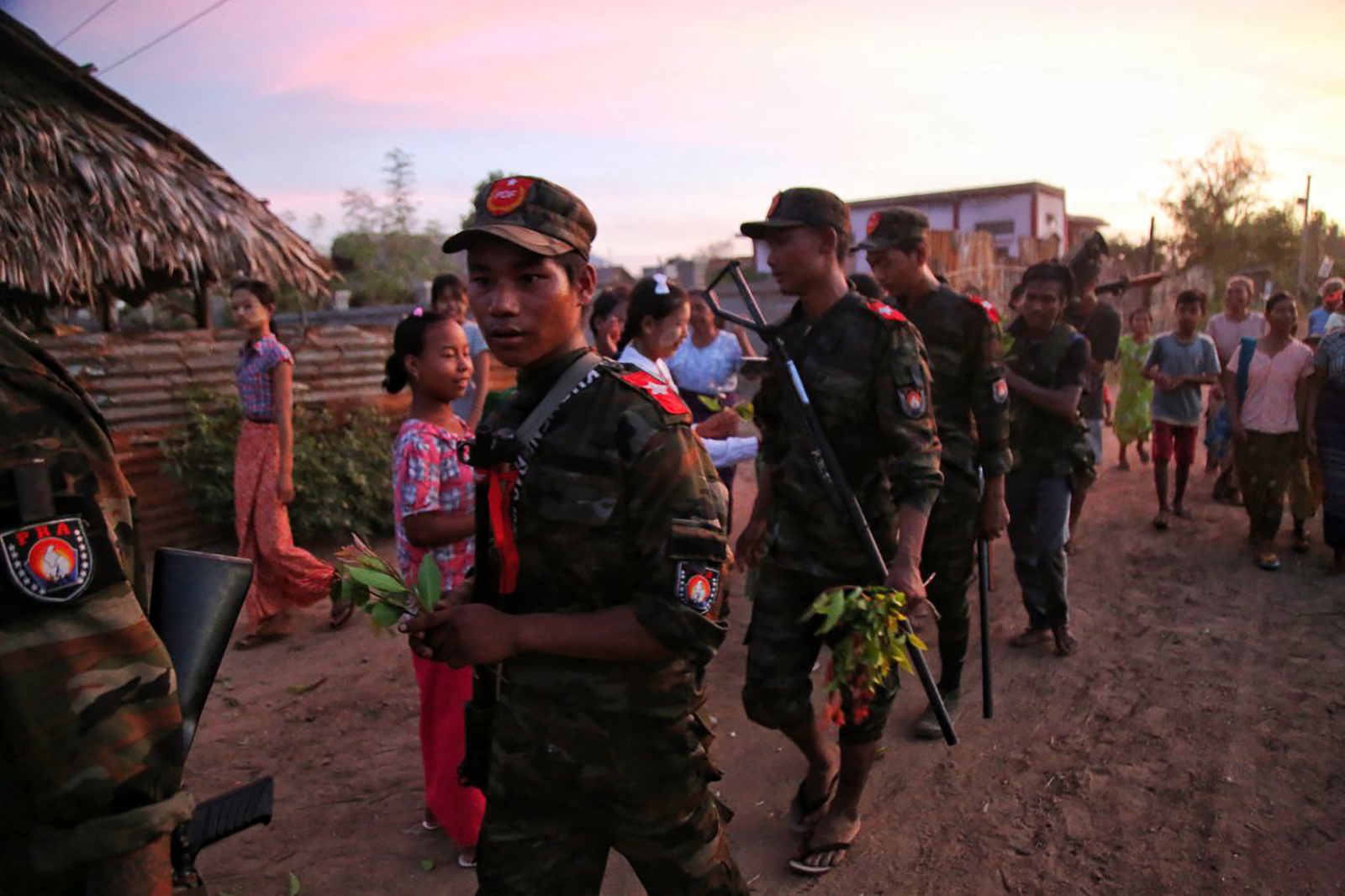 Residents of a village in Sagaing Region hand flowers to resistance fighters on August 16, 2022. (AFP)