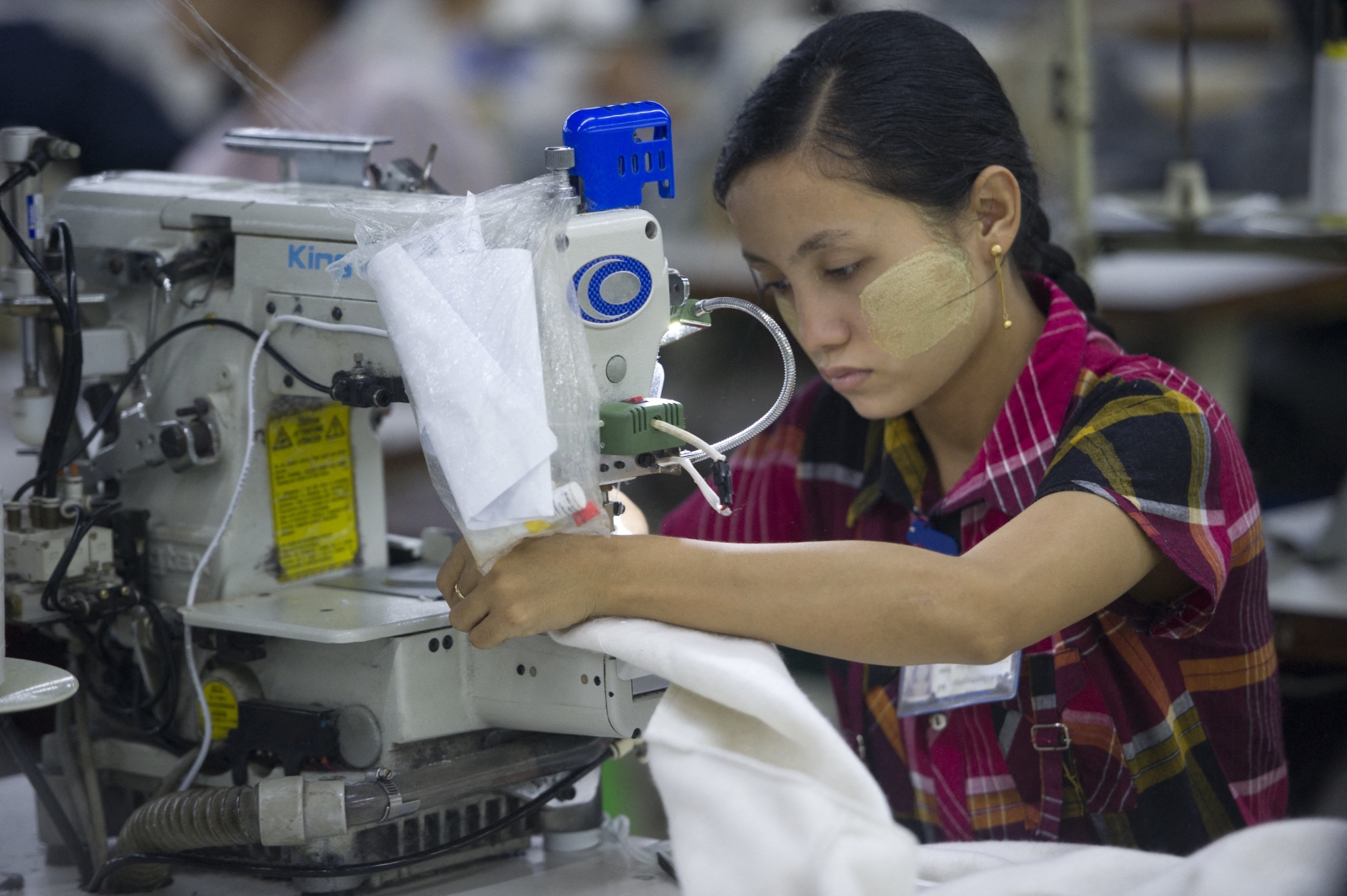 A woman works at a garment factory in Yangon’s Shwepyithar Township on September 18, 2015. (AFP)