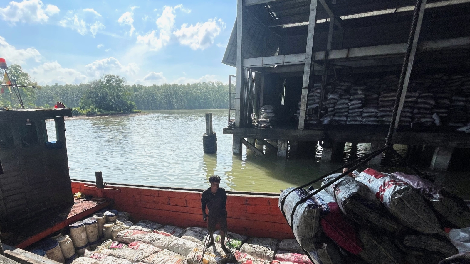 Sacks of Myanmar charcoal are unloaded in a waterside warehouse in the Thai port town of Ranong in December 2023. (Frontier)