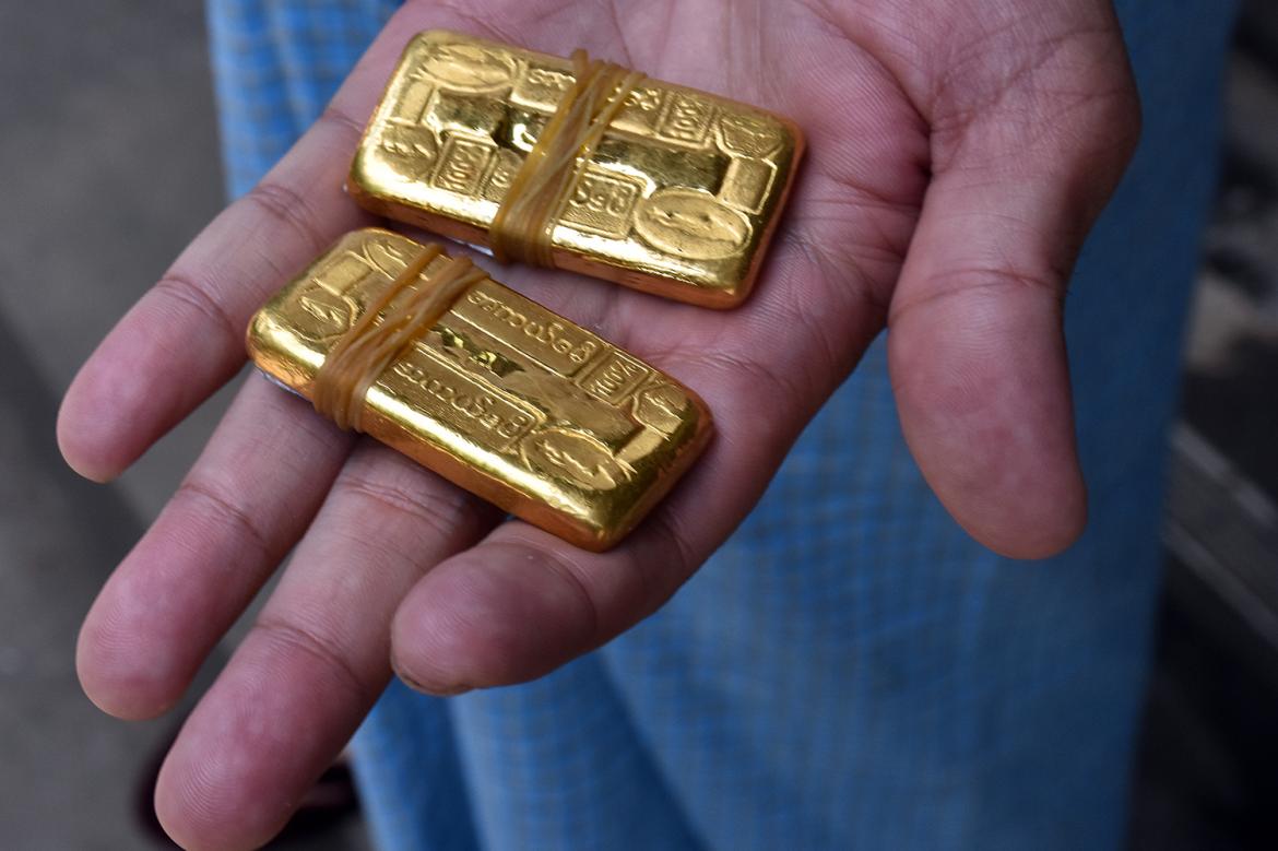 A man holds bars of gold in Yangon. (Frontier)